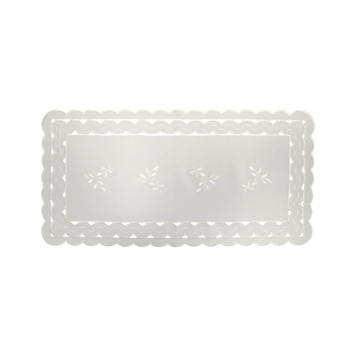 White linen table runner with scalloped cutwork edges and subtle leaf tendril embroidery