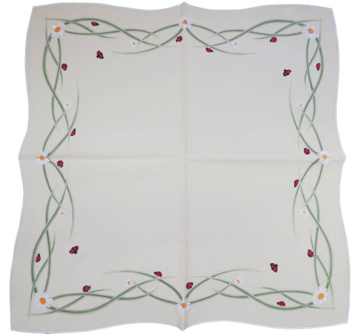 White square linen tablecloth with daisy and ladybug embroidery along the border with green stems