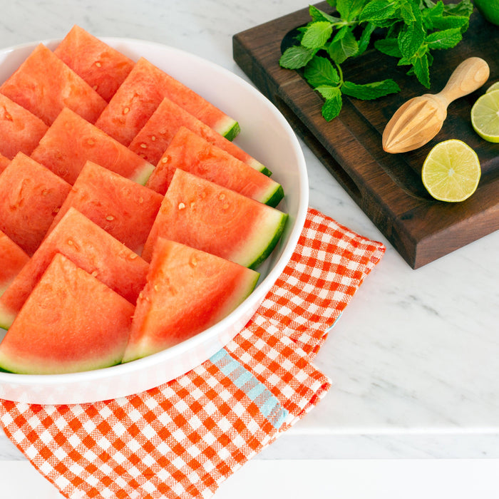 Luce Large Ceramic Serving Dish, white, round, filled with watermelon slices.