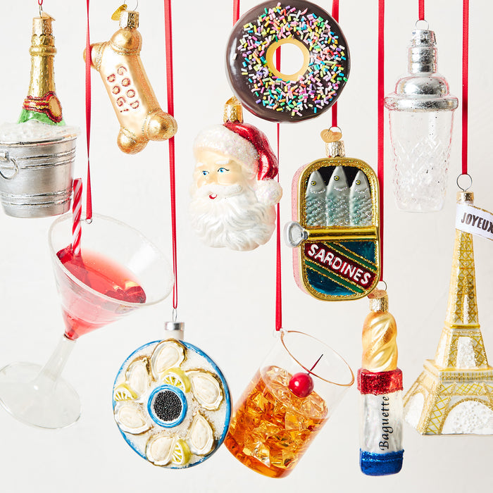 Hand-painted glass Manhattan cocktail ornament with a red cherry garnish, hanging on a red ribbon.