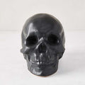 Matte black ceramic Halloween skull, 5.5”H x 7”W, with realistic features.