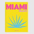 Hudson Grace Miami Beach coffee table book with a bright yellow cover, pink text, and blue palm leaf illustration.
