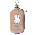 Miffy Key Case: A pinkish-beige faux-leather pouch with Miffy illustration, featuring a zipper, keyring, and dual compartments for smart and house keys.