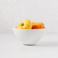 White ceramic HG Modern Small Serve Bowl with yellow and orange heirloom tomatoes.