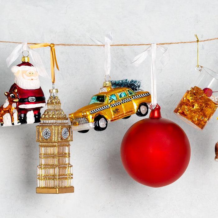 Hand-painted yellow NYC taxi cab glass Christmas ornament with glitter accents, 5 inches long.