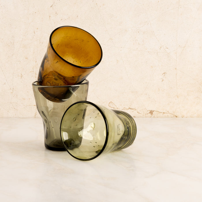 Stacked and fallen Olive Henri 8 oz. mouth-blown glass tumblers with unique imperfections and air bubbles.
