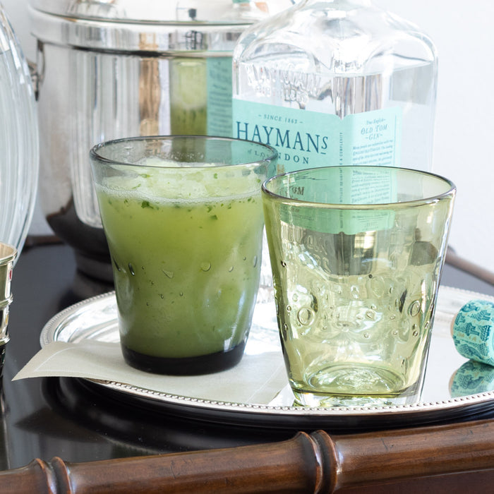 Olive Henri 8 oz. mouth-blown glass with unique imperfections, next to a matching glass with a green drink.