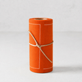An orange roll of paper or fabric with white stitched border lines and tied with a natural jute string, set against a light gray background.