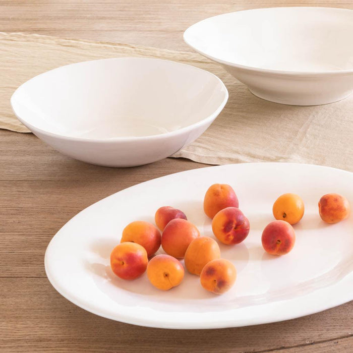 Creamy white ceramic flared serving bowl with subtle organic edges, 12" diameter.