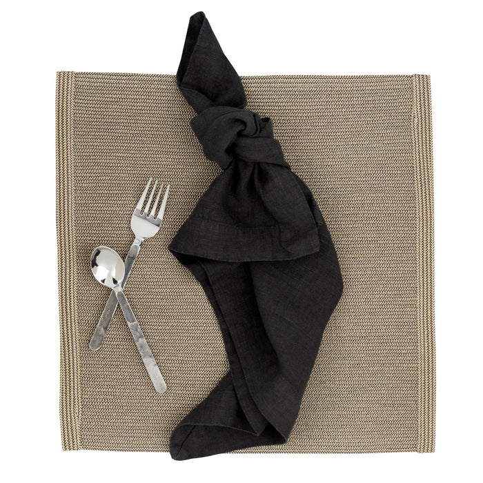 Orleans 5-piece stainless steel flatware set with hand-hammered texture, black napkin, and woven placemat.