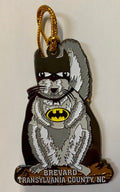 A metal ornament in the shape of a white squirrel wearing a Batman costume.