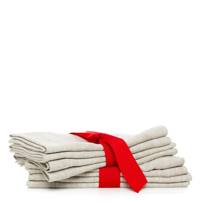 Stack of four oversized natural washed flax linen napkins tied with a red ribbon.