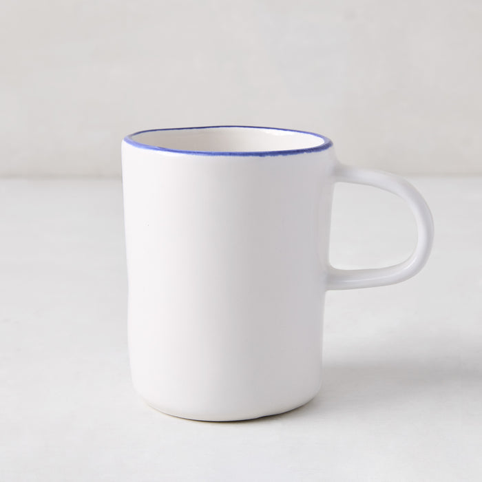 Pacific Blue-Rimmed Stoneware Mug, white with hand-painted blue edge, irregular shape.