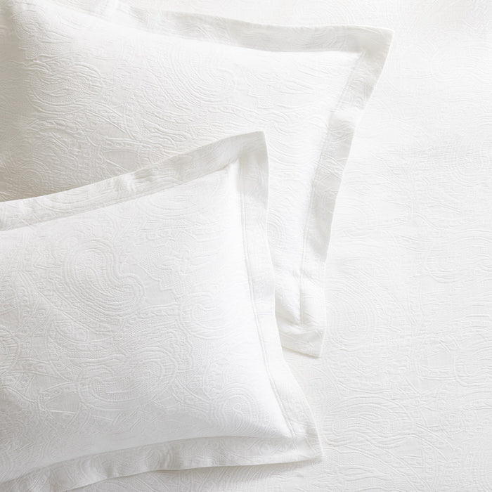 White cotton matelassé shams with subtle paisley pattern and tailored 2-inch hem.
