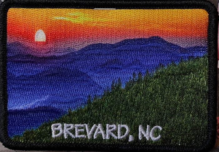 A patch with a photo-over mountain sunset scene, with the text 'BREVARD, NC' at the bottom.