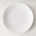 Pebble White 11" ceramic dinner plate with subtle textured surface and creamy white glaze.