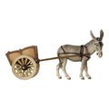 Hand-carved PEMA Kostner nativity donkey wearing a white bridle and dark harness, pulling a wooden two-wheel cart, crafted from sycamore maple and oil-painted in Val Gardena, Italy.
