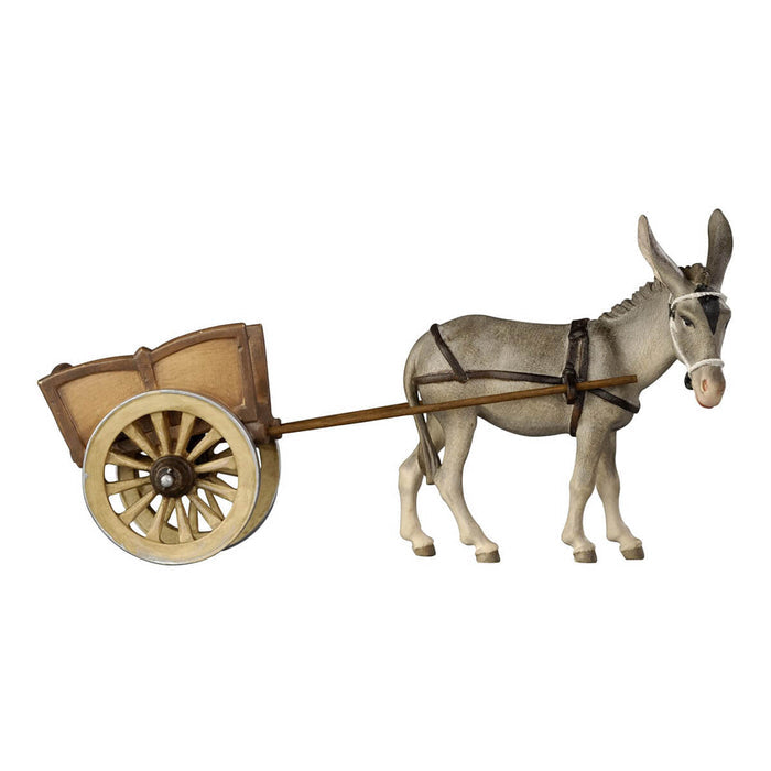 Hand-carved PEMA Kostner nativity donkey wearing a white bridle and dark harness, pulling a wooden two-wheel cart, crafted from sycamore maple and oil-painted in Val Gardena, Italy.