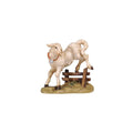 Hand-carved PEMA Kostner nativity lamb wearing a small bell and jumping over a wooden fence, crafted from sycamore maple and oil-painted in Val Gardena, Italy.