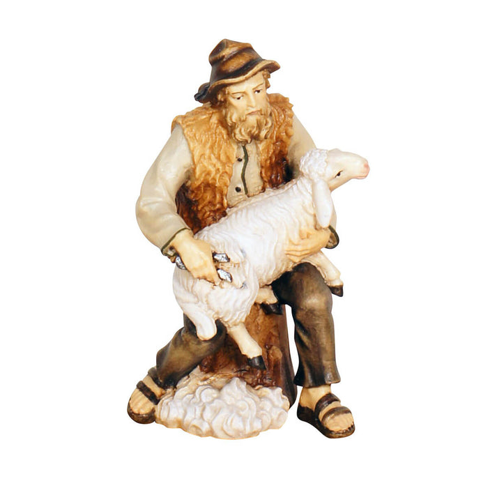 Hand-carved PEMA Kostner nativity shepherd sitting while shearing a sheep, made from sycamore maple wood and oil-painted, crafted in Val Gardena, Italy.