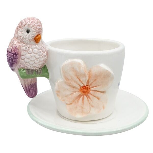 Ceramic cup and saucer with a decorative parrot figurine
