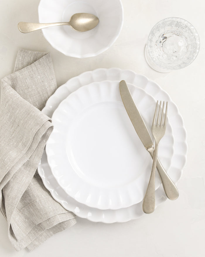 White Petal Stoneware Bowl, 6" diameter, with matching dinnerware, linen napkin, and silverware.