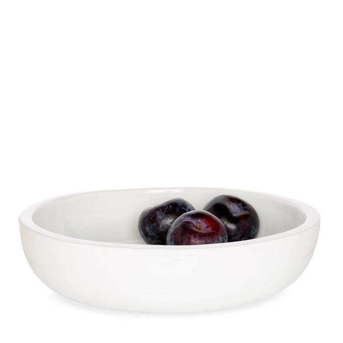 White ceramic serve bowl with three dark plums inside.