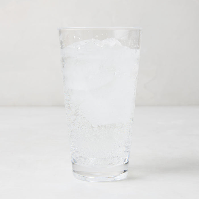 Clear acrylic highball glass with ice and sparkling water.