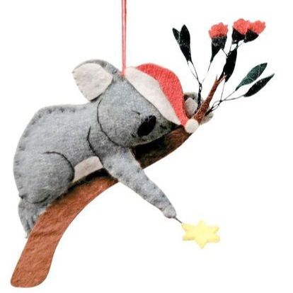 Decorative koala ornament with a Santa hat on a branch