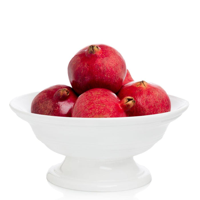 White ceramic footed bowl, 11.5"Dia. x 6"H, filled with red pomegranates.
