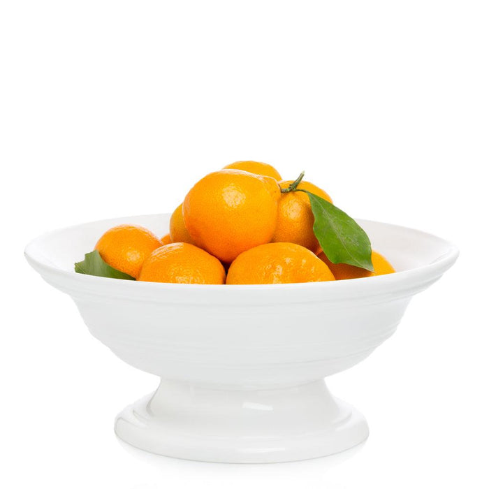 White ceramic footed bowl, 11.5"Dia. x 6"H, filled with oranges and green leaves.