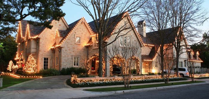 Certified Lights sample pack of white C9 bulbs for holiday decorating, showcasing a stone house adorned with warm, festive lights.