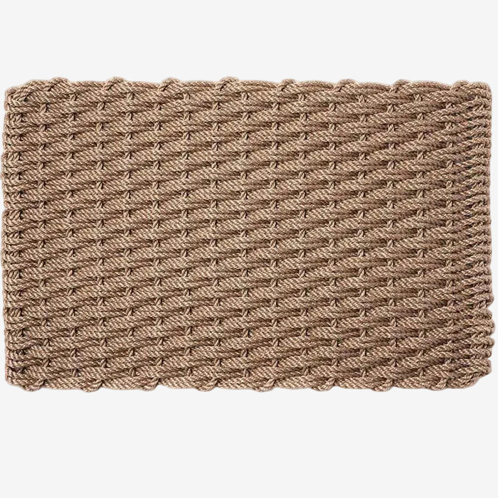 Sand braided rope doormat, handwoven, rectangular, with a textured, tightly woven pattern.
