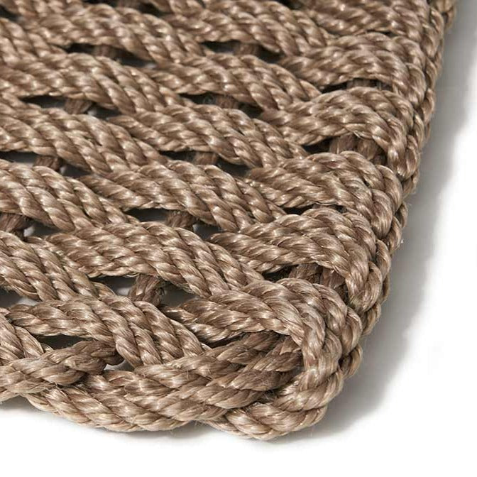 Sand braided rope doormat, handwoven, close-up of texture and corner.