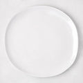 Sandia White 11" round melamine dinner plate with matte exterior and glossy interior.