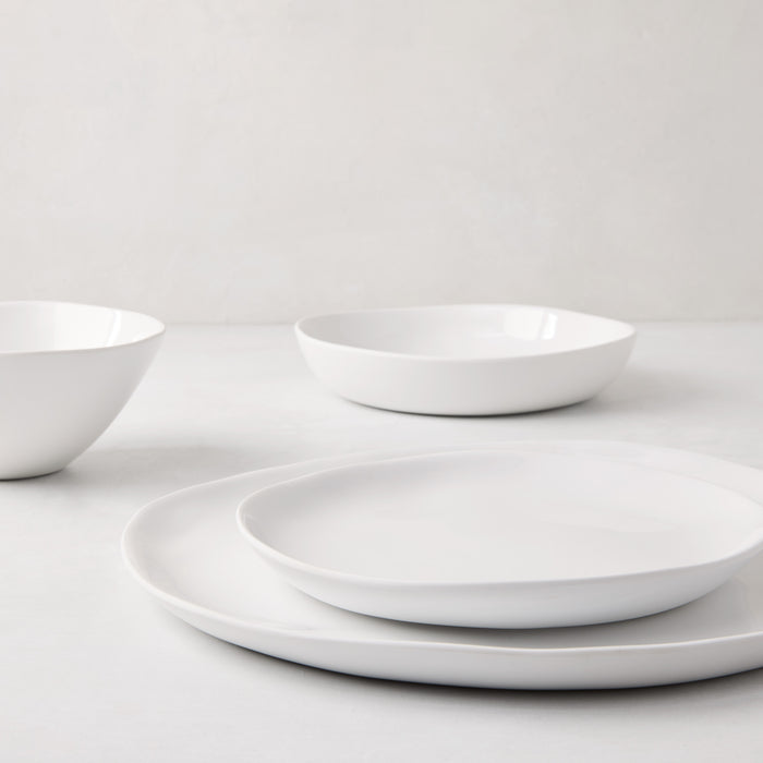 Sandia White 11" melamine dinner plate with organic, hand-thrown-inspired curves and a glossy interior.