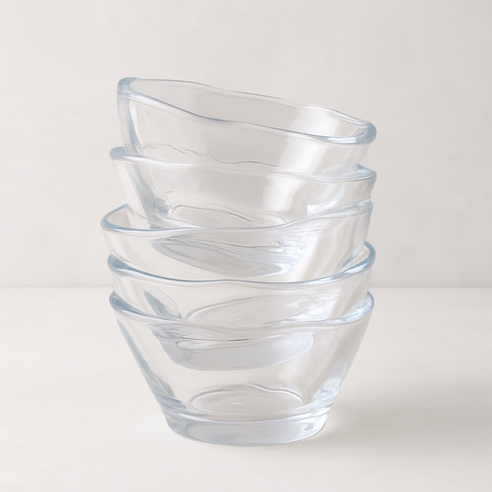 Stack of five clear, handmade glass breakfast bowls with unique scissor-cut tops.