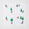 Set of 4 white linen coasters with embroidered skiers in red and blue, and green trees.