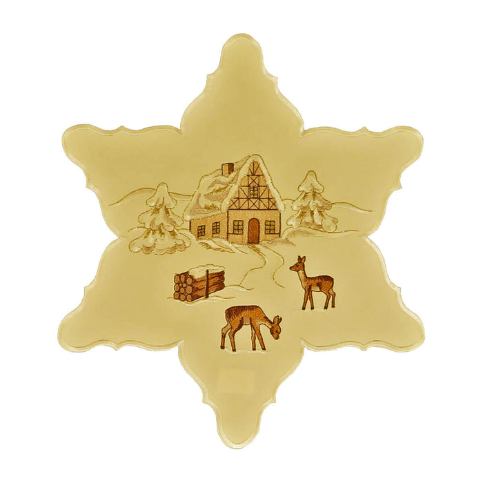 Star shaped cream color table linen, with a center design of a snow-covered chalet and trees, deer, and a bundle of wood.
