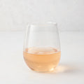 Clear stemless all-purpose glass filled with light pink rosé wine, 16.75 oz. capacity.