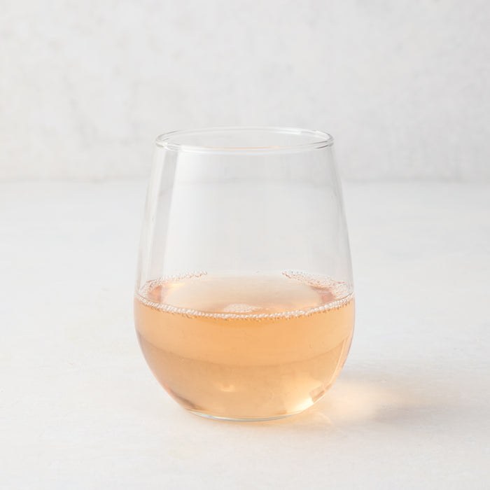 Clear stemless all-purpose glass filled with light pink rosé wine, 16.75 oz. capacity.
