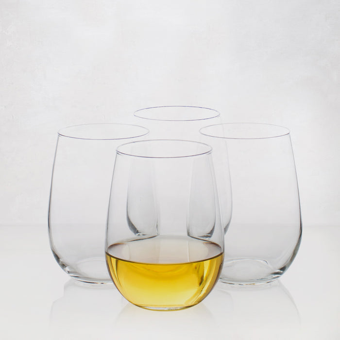 Four clear Hudson Grace stemless all-purpose wine glasses, one filled with amber liquid.