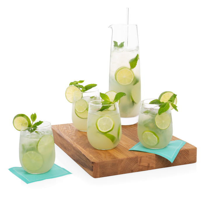Four clear stemless all-purpose wine glasses and a pitcher filled with mojitos on a wooden board.