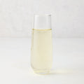 Clear Hudson Grace stemless champagne flute with sparkling light yellow liquid.