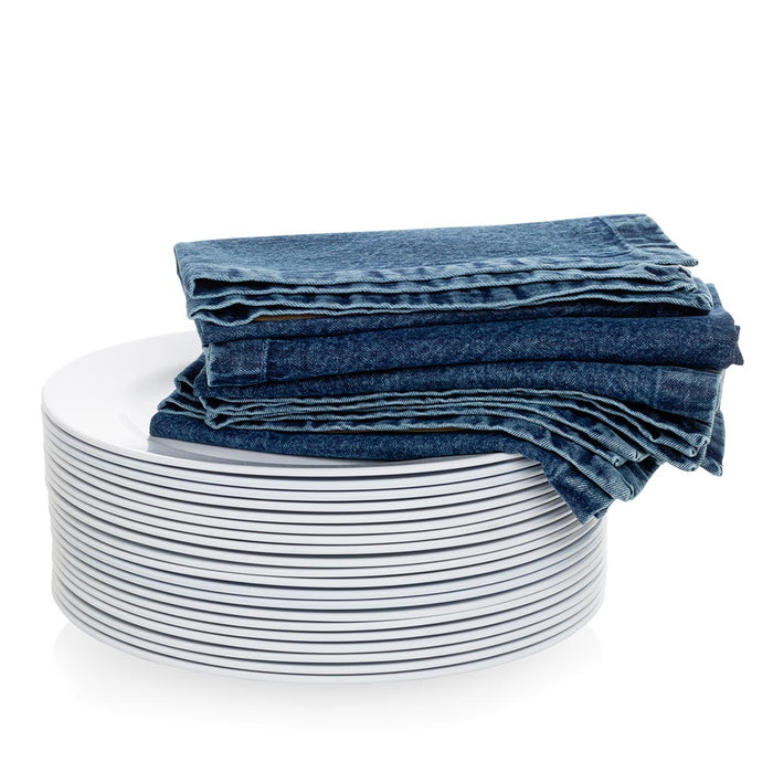 Stack of stonewashed blue denim napkins, 20" square, folded on white plates.
