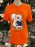 An orange short-sleeved crew neck t-shirt with a graphic of a white squirrel holding a beer and the phrase 'Hi, I'm here to cause problems.