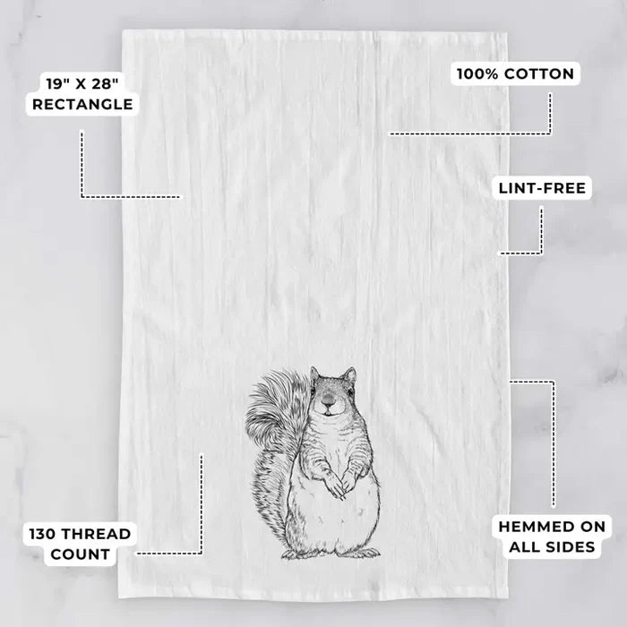 Tea towel with a squirrel design on a light gray background, featuring text about dimensions and material.