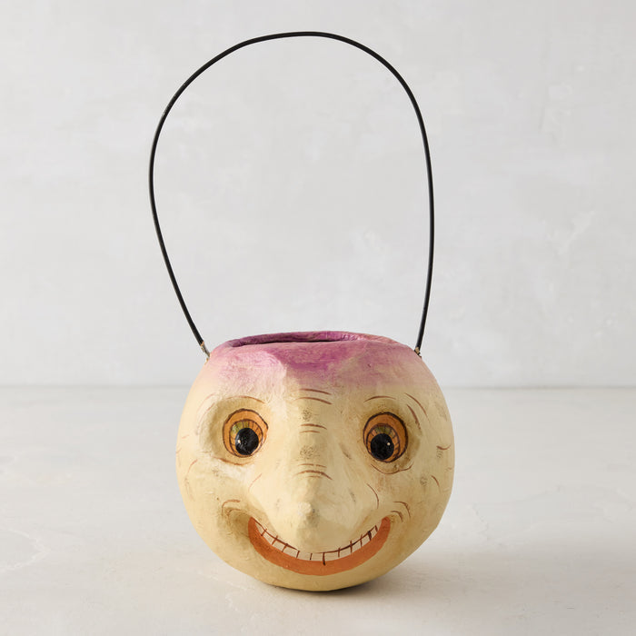Handcrafted papier-mâché turnip Halloween candy bucket with a distressed finish, smiling face, and black wire handle.