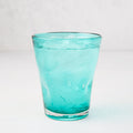 Turquoise Henri mouth-blown glass, 8 oz, with ice and water, showing unique imperfections.