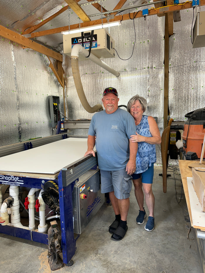 Owners of Yard Art Decor and More standing proudly in their Scottsburg, Indiana workshop beside a ShopBot CNC machine used for cutting durable MDO yard signs